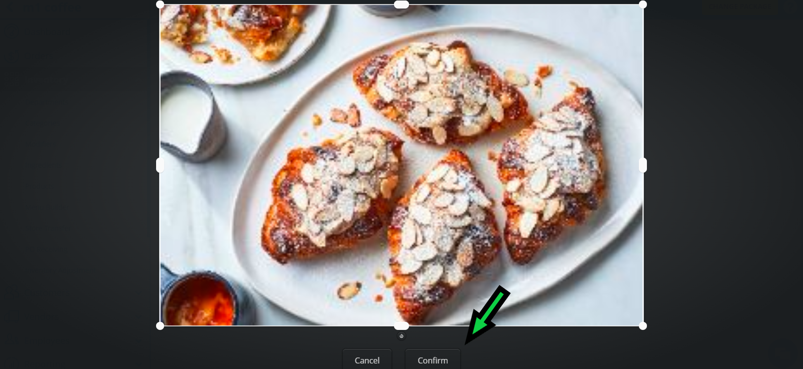 plate of almond-topped pastries on a white platter with a small sauce pitcher nearby.