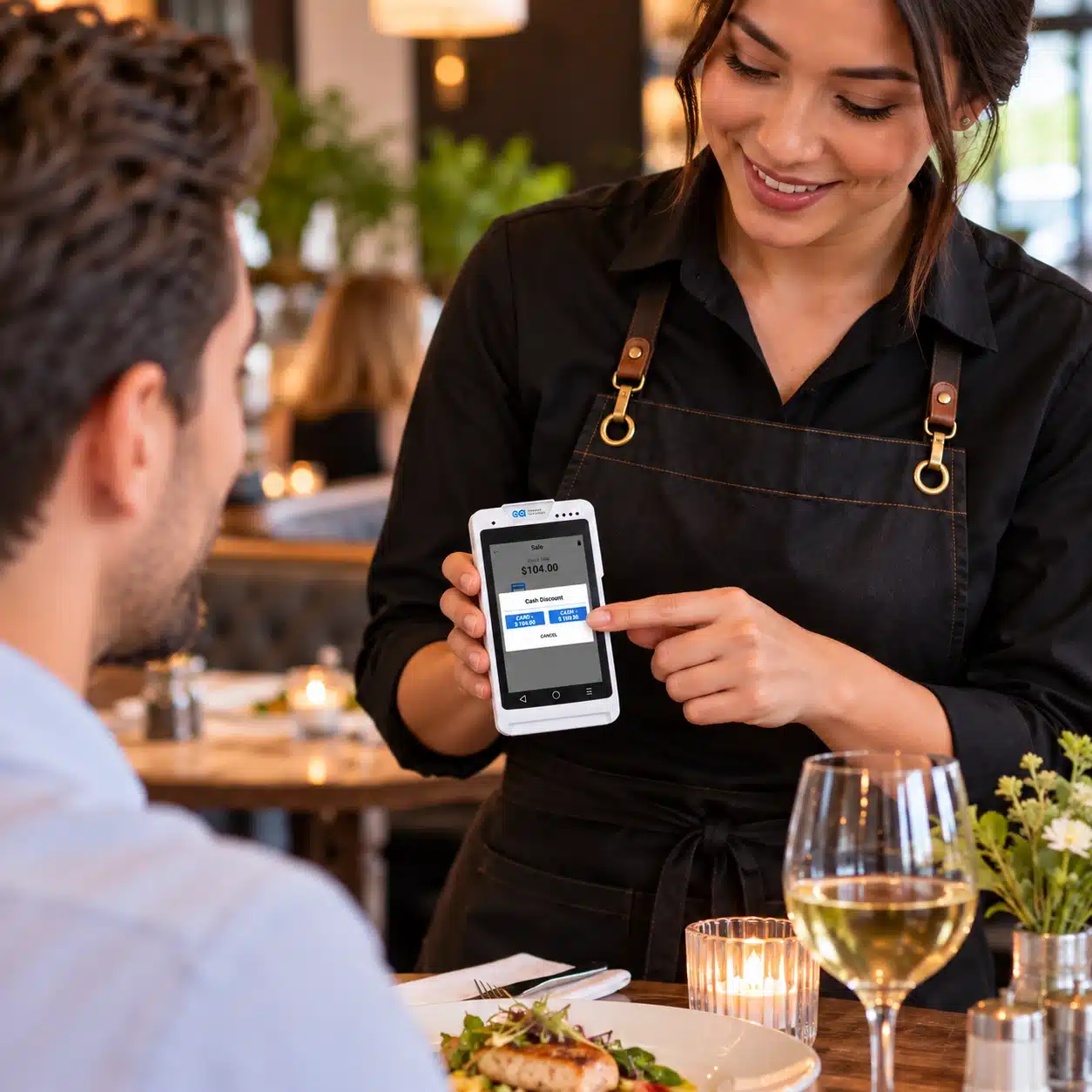 Q3 Payment Terminal for Restaurant | CHARGE Anywhere restaurant server showing a handheld payment device to a dining customer at the table.